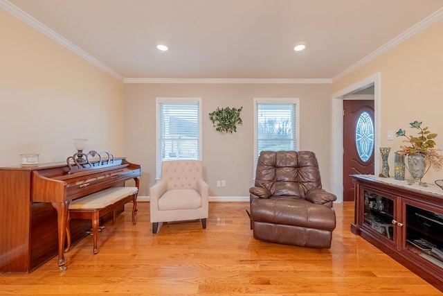 sitting room with a wealth of natural light, baseboards, crown molding, and light wood finished floors