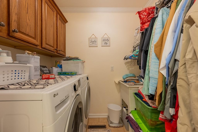 laundry area with washer and clothes dryer, light tile patterned floors, cabinet space, ornamental molding, and baseboards