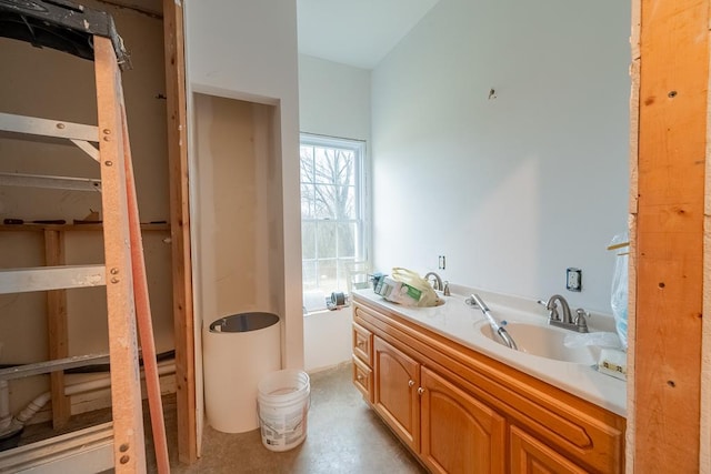 bathroom featuring a washtub, concrete floors, and vanity