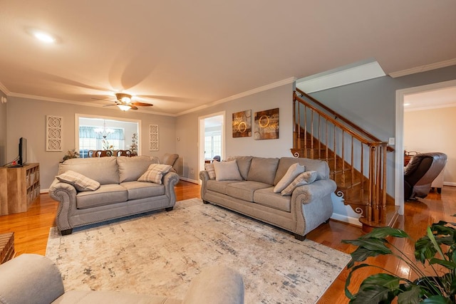 living room featuring stairs, ornamental molding, wood finished floors, and baseboards