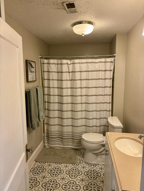 bathroom with vanity, walk in shower, a textured ceiling, and toilet