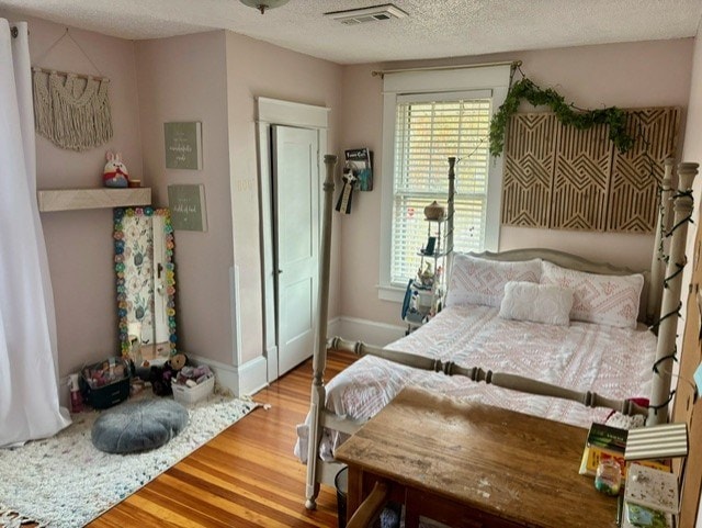 bedroom with hardwood / wood-style floors and a textured ceiling