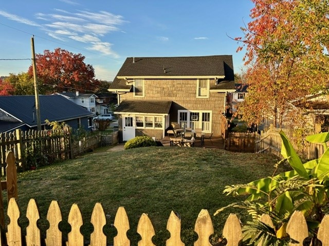 rear view of property featuring a yard