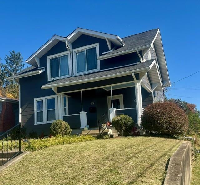 view of front of home with covered porch and a front lawn