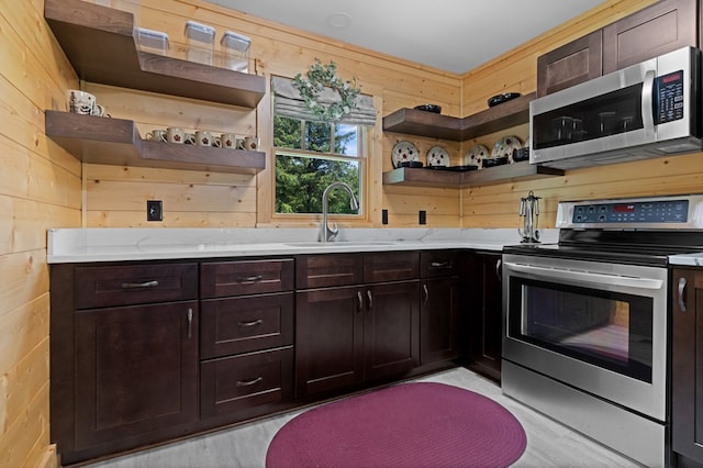 558 Pops Peak Rd, Fancy Gap, VA 24328 - kitchen with appliances with stainless steel finishes, open shelves, wood walls, dark brown cabinets, and light stone counters