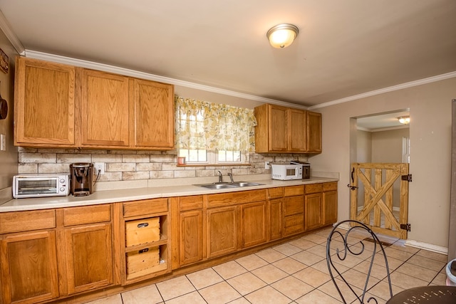 kitchen featuring a toaster, a sink, white microwave, decorative backsplash, and crown molding