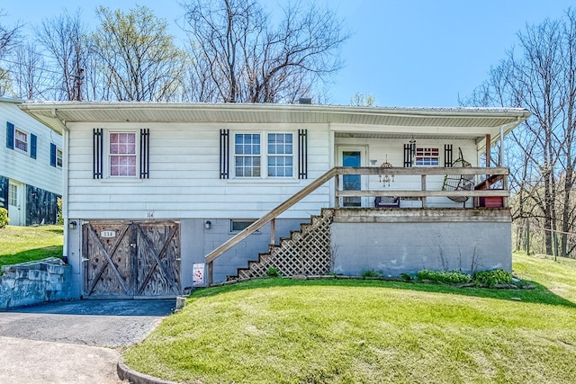 view of front of property featuring an attached garage, a front lawn, and covered porch