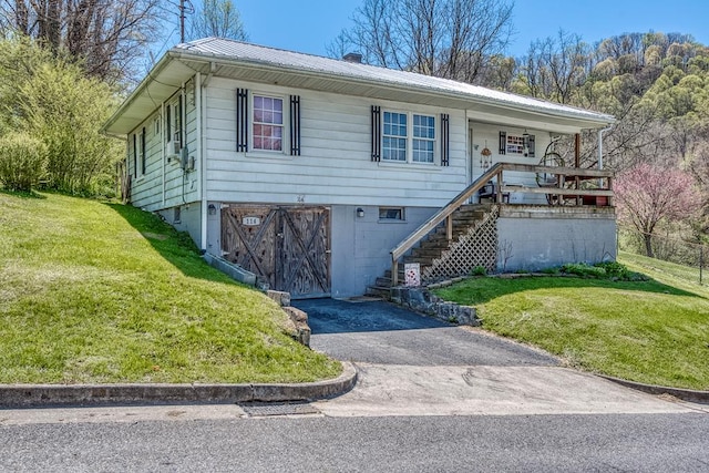 view of front of home with a garage, a front yard, metal roof, and aphalt driveway