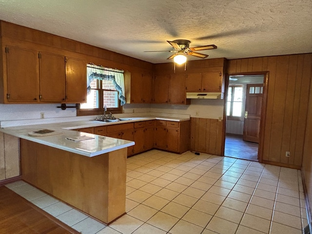 4127 Steelsburg Hwy, Cedar Bluff, VA 24609 - kitchen with a sink, a peninsula, under cabinet range hood, light countertops, and brown cabinets