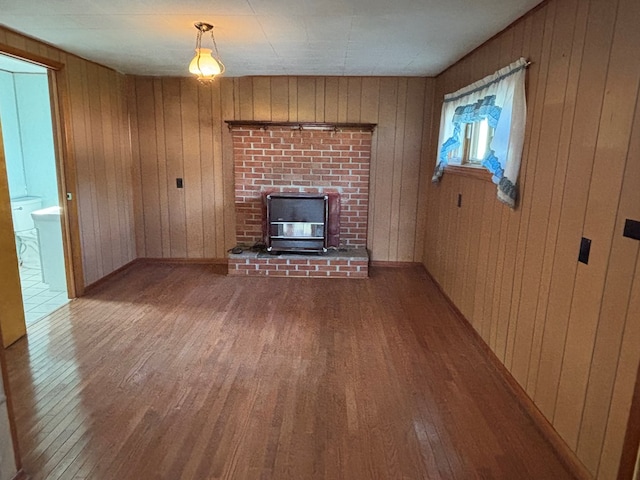 4127 Steelsburg Hwy, Cedar Bluff, VA 24609 - unfurnished living room featuring wood finished floors, wood walls, and a brick fireplace
