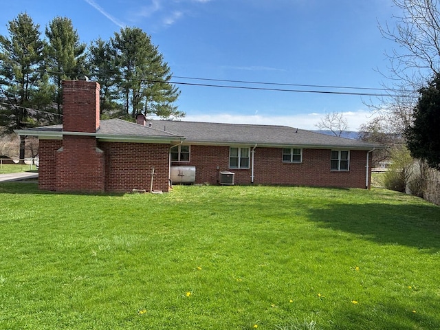4127 Steelsburg Hwy, Cedar Bluff, VA 24609 - back of property with a chimney, central AC unit, a lawn, and brick siding