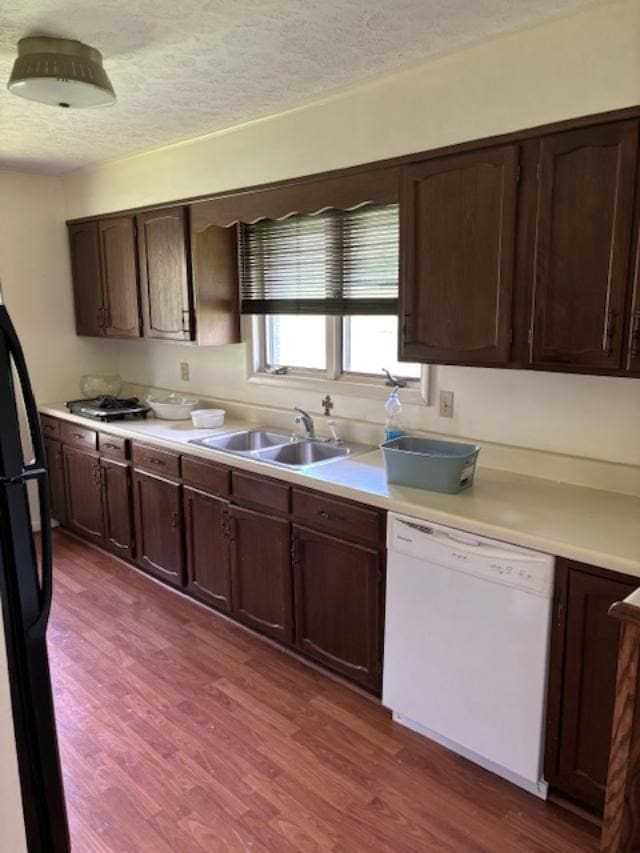 319 Bogey Dr, Abingdon, VA 24211 - kitchen with dark wood finished floors, light countertops, white dishwasher, freestanding refrigerator, and a textured ceiling