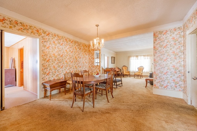 carpeted dining area with ornamental molding, a chandelier, and a textured ceiling