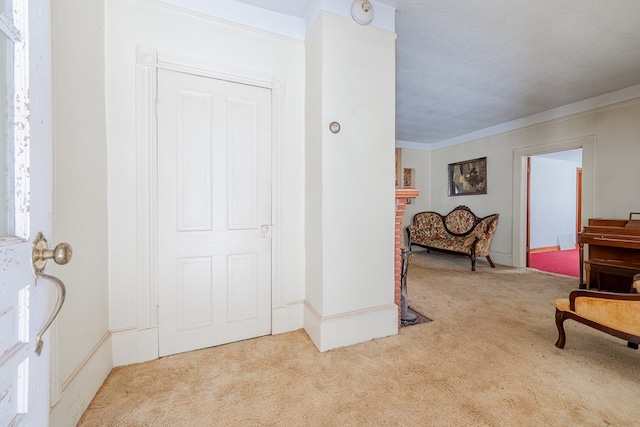 carpeted entryway featuring crown molding and a textured ceiling