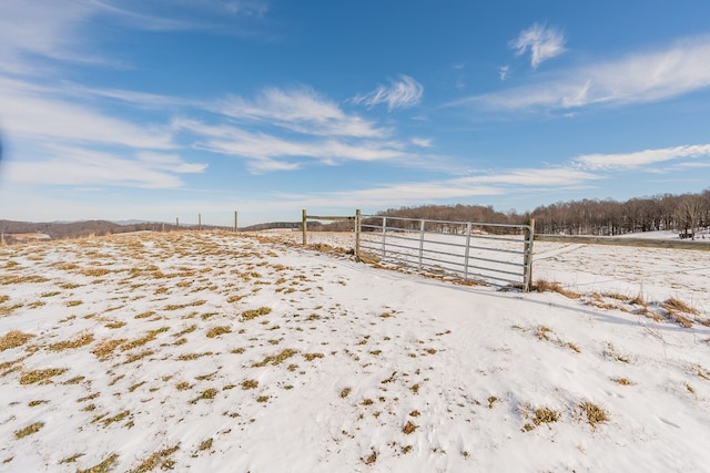 snowy yard featuring a rural view