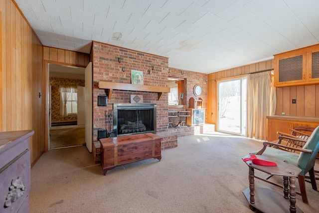 carpeted living room with a fireplace and wooden walls