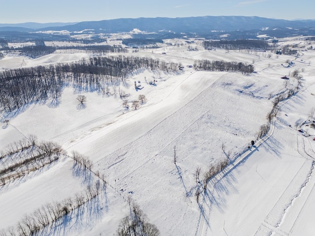 snowy aerial view featuring a mountain view