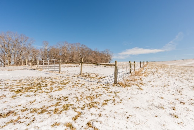 yard layered in snow with a rural view