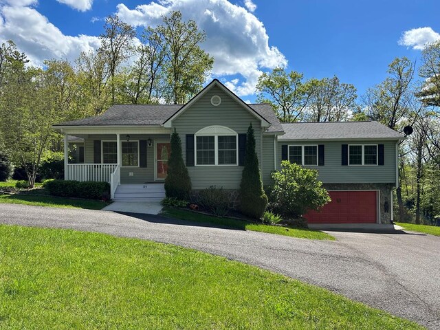 185 Laurel Dr, Fancy Gap, VA 24328 - single story home featuring asphalt driveway, a garage, covered porch, a front lawn, and roof with shingles