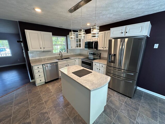 185 Laurel Dr, Fancy Gap, VA 24328 - kitchen with appliances with stainless steel finishes, a sink, baseboards, a kitchen island, and white cabinetry