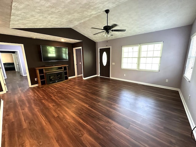 unfurnished living room with ceiling fan, wood finished floors, lofted ceiling, baseboards, and healthy amount of natural light