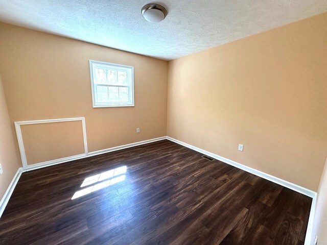 185 Laurel Dr, Fancy Gap, VA 24328 - unfurnished room with dark wood finished floors, baseboards, and a textured ceiling