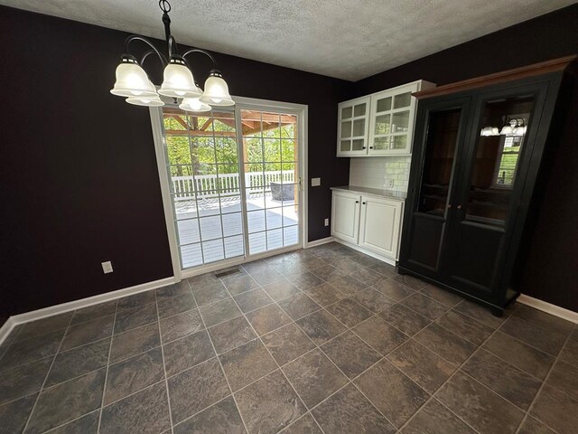 185 Laurel Dr, Fancy Gap, VA 24328 - unfurnished dining area featuring a chandelier, baseboards, and a textured ceiling