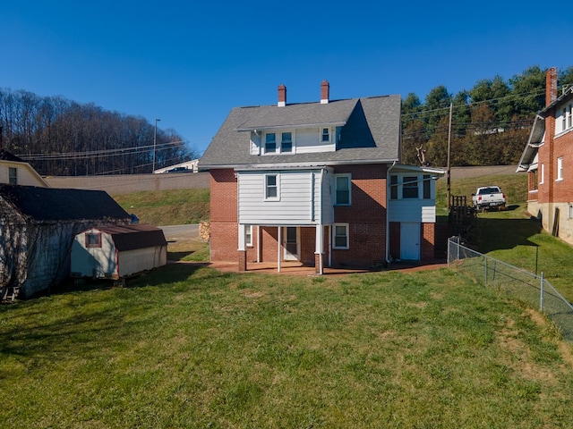 back of house featuring a yard and a storage shed