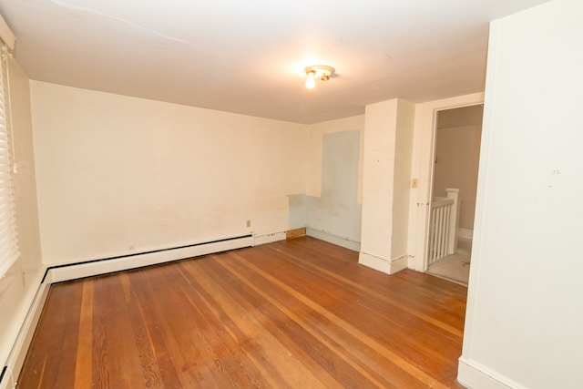 unfurnished room with hardwood / wood-style floors and baseboard heating