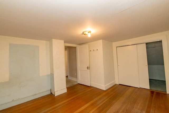 unfurnished bedroom featuring wood-type flooring and a closet