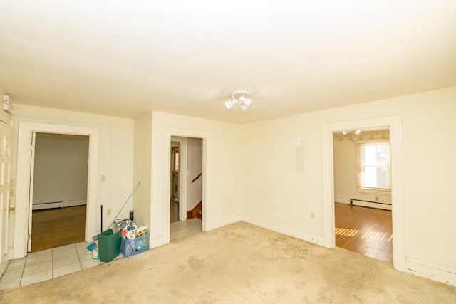 unfurnished room featuring light carpet and baseboard heating