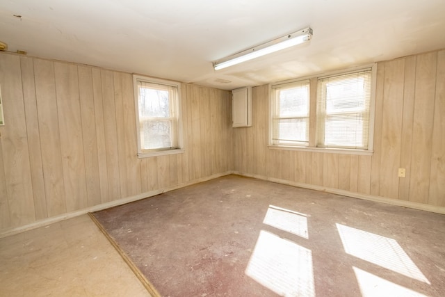empty room featuring plenty of natural light and wood walls