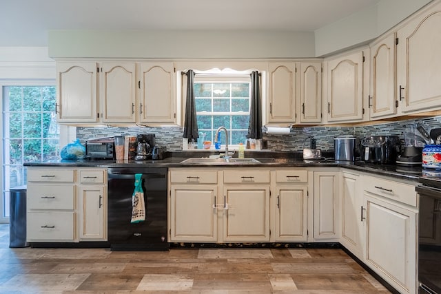 kitchen featuring tasteful backsplash, sink, light hardwood / wood-style floors, and dishwasher