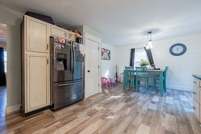 kitchen featuring cream cabinetry, decorative light fixtures, stainless steel fridge with ice dispenser, and light wood-type flooring