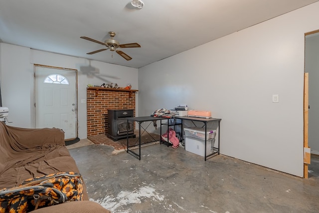 living room with a wood stove and ceiling fan