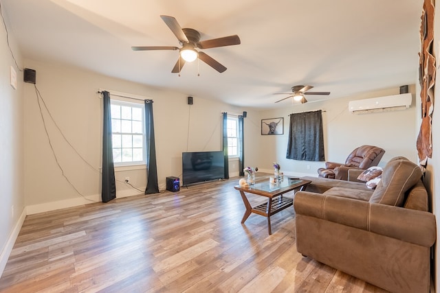 living room with ceiling fan, an AC wall unit, and light hardwood / wood-style floors