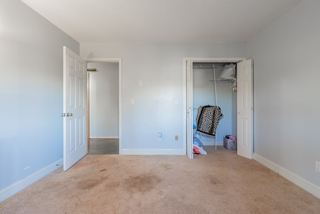 unfurnished bedroom with light carpet and a closet