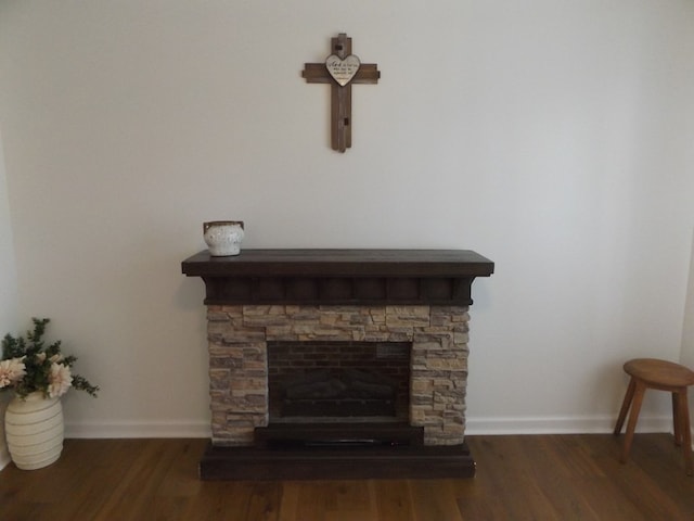 room details featuring a fireplace, baseboards, and wood finished floors