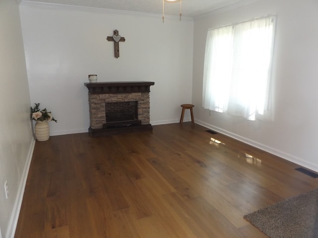 unfurnished living room with wood finished floors, ornamental molding, visible vents, a fireplace, and baseboards
