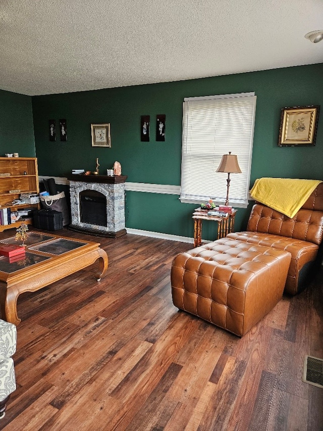 419 Tanglewood Dr, Glade Spring, VA 24340 - living room with a textured ceiling, baseboards, a stone fireplace, visible vents, and wood finished floors