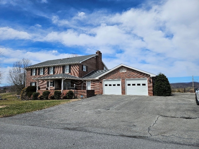 419 Tanglewood Dr, Glade Spring, VA 24340 - view of front facade with a porch, aphalt driveway, brick siding, a garage, and a chimney
