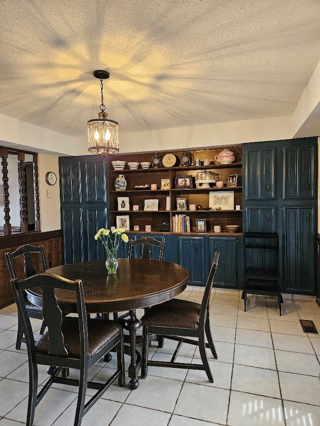 419 Tanglewood Dr, Glade Spring, VA 24340 - dining space with a textured ceiling, a notable chandelier, a wainscoted wall, and light tile patterned floors