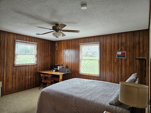 419 Tanglewood Dr, Glade Spring, VA 24340 - bedroom with multiple windows, wooden walls, ceiling fan, and light colored carpet
