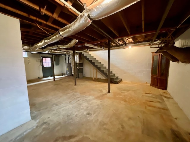 basement featuring water heater and stairway