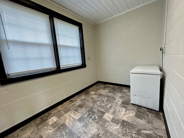 spare room featuring concrete block wall