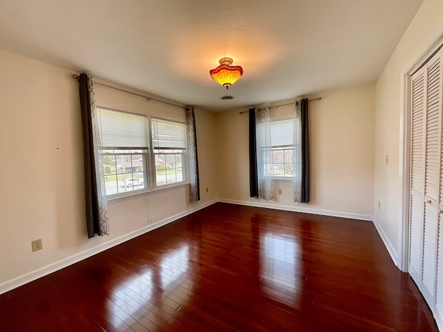 unfurnished bedroom featuring wood-type flooring and baseboards