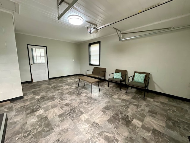living area with baseboards and a garage