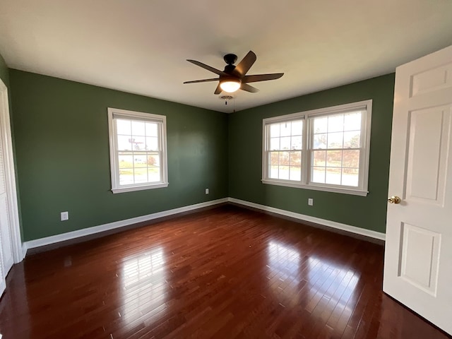 spare room featuring dark wood finished floors, baseboards, and ceiling fan