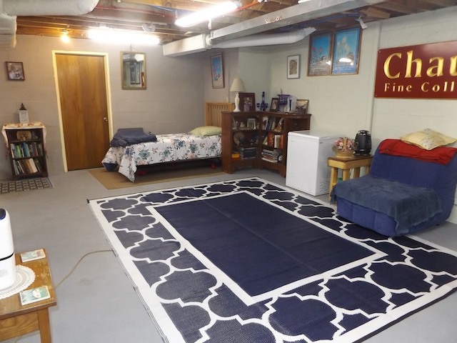 bedroom with refrigerator and concrete floors