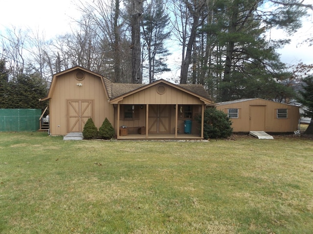 back of house featuring a shed and a lawn